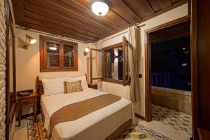 a bedroom with a bed and a window at Sam Franss Boutique Otel in Hatay