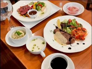 una mesa de madera cubierta con platos de comida y bebida en APA Hotel Ningyocho-eki Kita, en Tokio