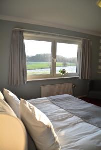 Un dormitorio con una cama grande y una ventana en Den Gamle Grænsekro Inn, en Christiansfeld