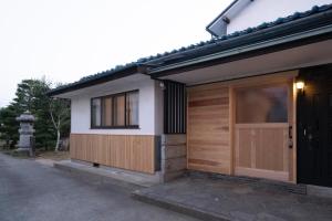 une maison avec une porte en bois et une fenêtre dans l'établissement Kominkahu kashikiri cottage Tokei - Vacation STAY 57497v, à Nagano