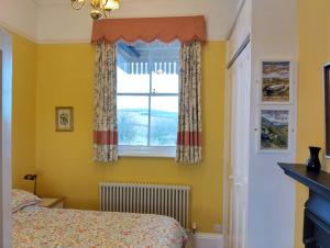 a bedroom with yellow walls and a window at Rowden Mill Station in Bromyard