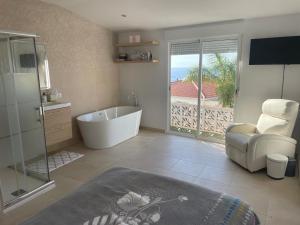 a bathroom with a tub and a chair and a television at Alojamiento de invitados in Sauzal