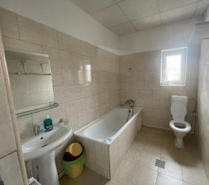 a bathroom with a tub and a toilet and a sink at Complex garsoniere. Studio Rentals in Onești