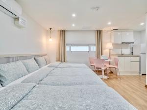 a bedroom with a large bed and a table at Harmony Stay in Seoul