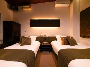 富士吉田的住宿－SWEET VILLA TAKASAMA，客房设有两张床和一台平面电视。