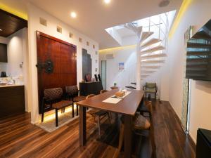 a dining room with a table and a spiral staircase at SWEET VILLA TAKASAMA in Fujiyoshida