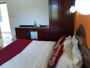 a bedroom with a bed with two pillows on it at Vedantha Inn in Kovalam