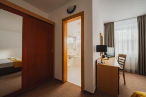 una habitación de hotel con una puerta que conduce a un dormitorio en Vila Horec - depandance hotela Hubert Vital Resort en Gerlachov