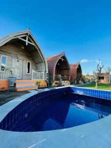 a home with a swimming pool in front of a house at Dimas Villa in Kintamani