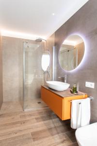 uma casa de banho com um lavatório e um espelho em Re Ottone Rooms em Lazise
