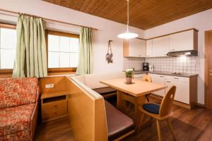 Appartement Hannes في Sand in Taufers: مطبخ وغرفة معيشة مع طاولة وأريكة