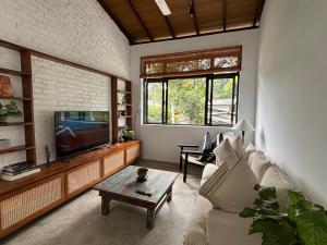 a living room with a couch and a tv at Rai Villa Colombo in Colombo