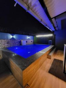 een groot zwembad in een kamer met een blauwe vloer bij THE PERFECT STAYS : TRANQUIL VILLA in Lonavala