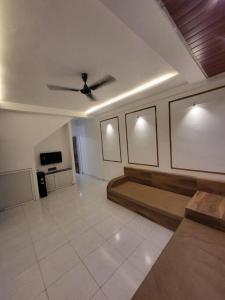 a living room with a ceiling fan and a couch at THE PERFECT STAYS : TRANQUIL VILLA in Lonavala