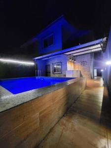 una piscina en una casa por la noche en THE PERFECT STAYS : TRANQUIL VILLA en Lonavala