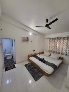 a bedroom with a large bed with a ceiling fan at THE PERFECT STAYS : TRANQUIL VILLA in Lonavala