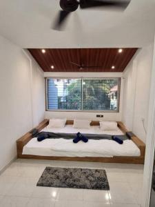 a large bed in a room with a window at THE PERFECT STAYS : TRANQUIL VILLA in Lonavala