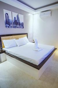 a bedroom with a large bed with a white sheets at G Hotel in Dauis