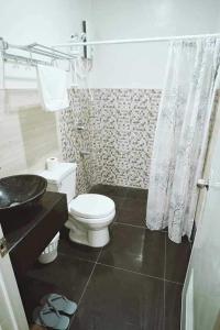 La salle de bains est pourvue de toilettes blanches et d'un lavabo. dans l'établissement G Hotel, à Dauis
