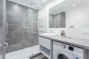 a white bathroom with a sink and a shower at Deo Plaza - apartamenty by Rent like home in Gdańsk