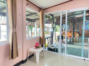 a room with windows and a table with flowers on it at Lanta Wild Beach Resort in Ko Lanta