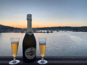 a bottle of beer and two glasses on a table at HOUSE BOAT OLIVA - Floating House in Pula