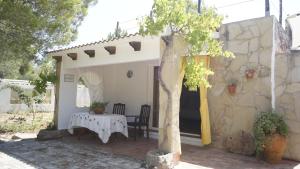 un patio con una mesa, una mesa y un árbol en El Campus, en Alaior