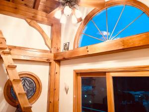 um quarto com um tecto de madeira e uma janela em Patagonia Home em Shimoda