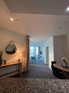 een woonkamer met een tafel en een spiegel aan de muur bij Exclusive Suite CBD Riverviews - ParkingOnsite in Melbourne