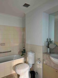 een badkamer met een toilet, een bad en een wastafel bij Exclusive Suite CBD Riverviews - ParkingOnsite in Melbourne