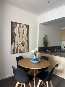 een tafel en stoelen in een keuken met een schilderij bij Exclusive Suite CBD Riverviews - ParkingOnsite in Melbourne