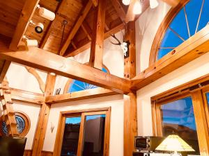 um quarto com tecto em madeira e janelas em Patagonia Home em Shimoda