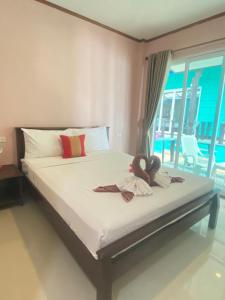 Un dormitorio con una cama con dos muñecas. en Lanta Wild Beach Resort, en Ko Lanta