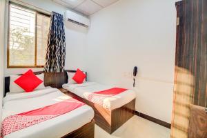 a room with two beds and a window at Anjali Hotel Jb Nagar Andheri in Mumbai