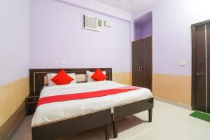 une chambre avec un grand lit avec des oreillers rouges dans l'établissement Hotel O Sunrise Inn, à Indirapuram
