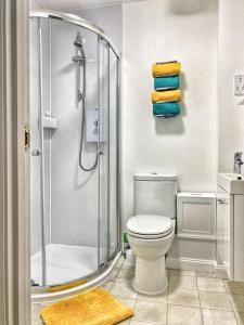 a bathroom with a shower and a toilet and towels at Ground floor Central 1 bed with parking in Aberdeen