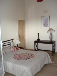 a bedroom with a bed and a table and a desk at appartement dans villa aquarelle in Biguglia