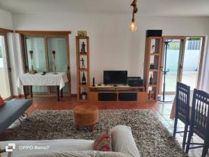 a living room with a couch and a tv at Residencial Monte Gordo Golf Rei Algarve in Monte Gordo