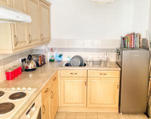 a kitchen with wooden cabinets and a stainless steel refrigerator at Ground floor Central 1 bed with parking in Aberdeen