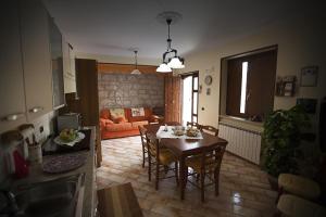 una cucina e un soggiorno con tavolo e sedie di B&b Il Gheppio a Campolattaro