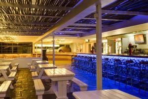 a bar with wooden tables and chairs in a restaurant at 358 Kaliva - Club Mykonos in Langebaan