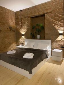 1 dormitorio con 1 cama grande y pared de ladrillo en Charming Historic Apartment F2, en Tiflis