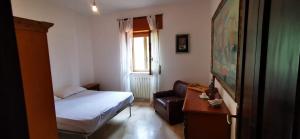 a small bedroom with a bed and a couch at Casa vacanze CALU' in Cittadella del Capo