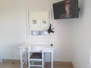un escritorio blanco con una foto de un hombre en la pared en 358 Kaliva - Club Mykonos en Langebaan