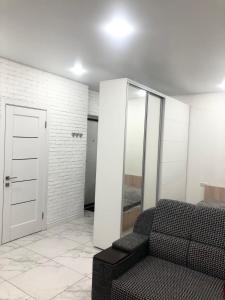 een woonkamer met een bank en een spiegel bij New Marine Apartment in Yuzhne