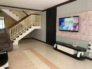 a living room with a tv on a wall at Barzoo Homes in Kisumu