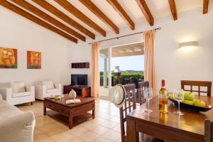 a living room with a table and a dining room at Villas Menorca Sur in Son Bou
