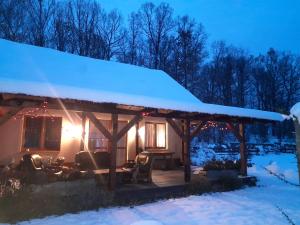 a cabin with a snow covered roof in the snow at Majcia in Jelenia Góra