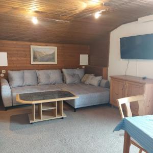 ein Wohnzimmer mit einem Sofa und einem Tisch in der Unterkunft Haus am Lärchenhang, Fewo5 in Leutasch