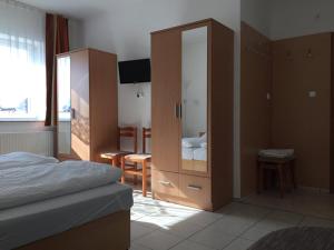 1 dormitorio con 1 cama, armario y escritorio en Lamar Apartman, en Kapuvár